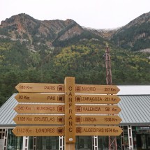 Distance signs with the new railway station building of Canfranc